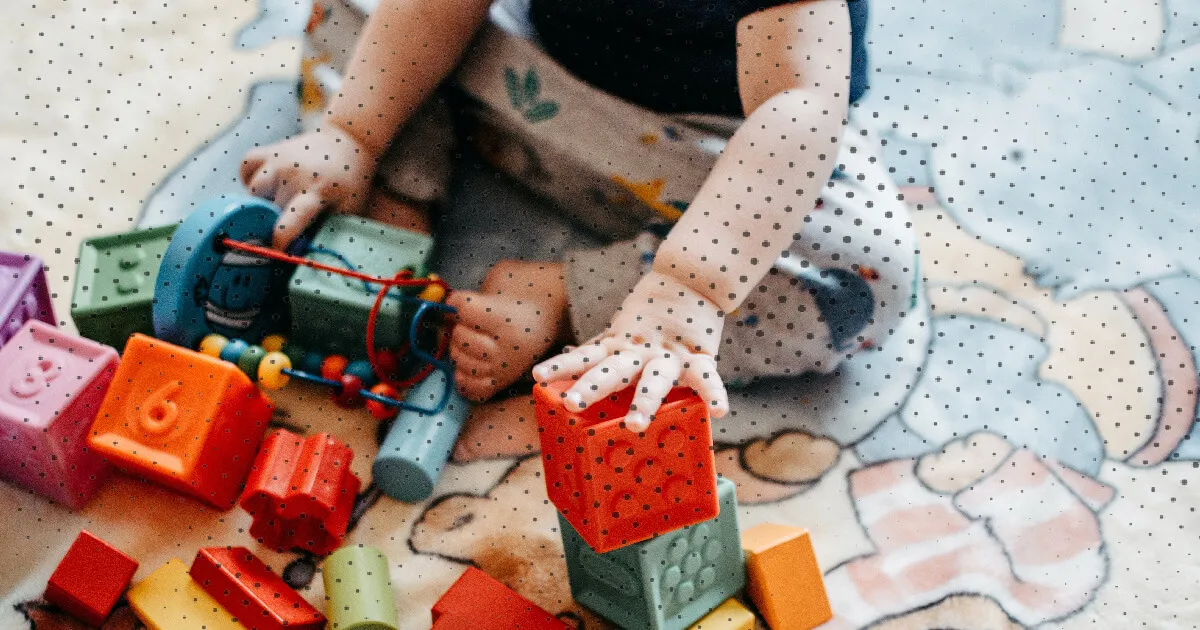 baby 6 maanden speelt met speelgoed 