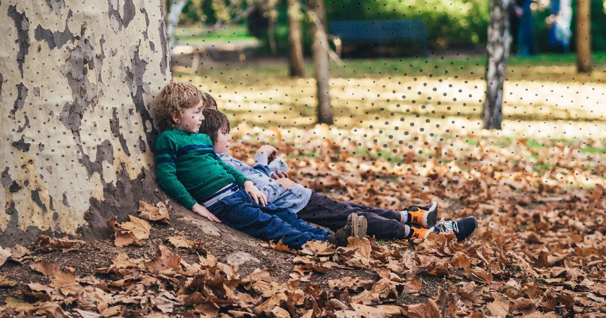 herfst speelgoed jongens zitten tegen boom 